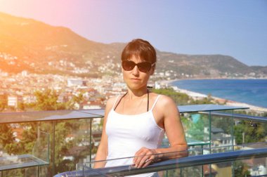 Deniz kıyısındaki tatil köyünün arka planında güzel bir kadın. Deniz Koyu.