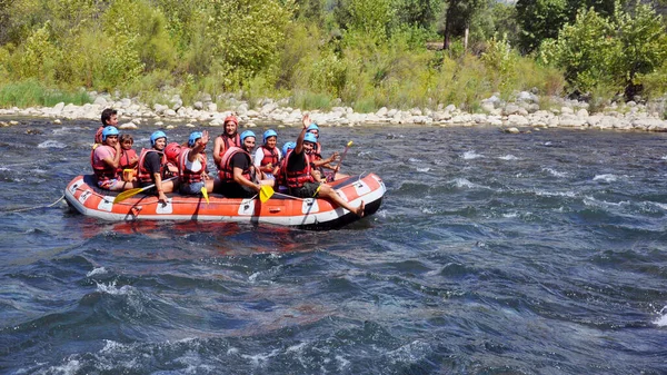 Rafting, um grupo de jovens com um rafting guia ao longo de um rio de montanha. Esporte extremo e divertido em uma atração turística . — Fotografia de Stock