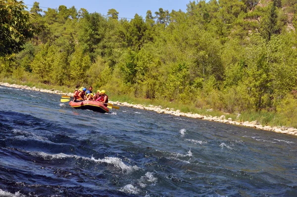 Rafting, um grupo de jovens com um rafting guia ao longo de um rio de montanha. Esporte extremo e divertido em uma atração turística . — Fotografia de Stock