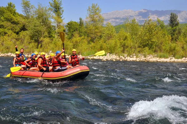 Rafting, Grupa młodych ludzi z przewodnikiem rafting wzdłuż górskiej rzeki. Ekstremalne i zabawne Sport w atrakcja turystyczna. — Zdjęcie stockowe