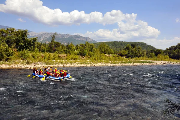 Rafting, un grup de tineri cu un ghid de rafting de-a lungul unui râu de munte. Sportul extrem și distractiv la o atracție turistică . — Fotografie, imagine de stoc