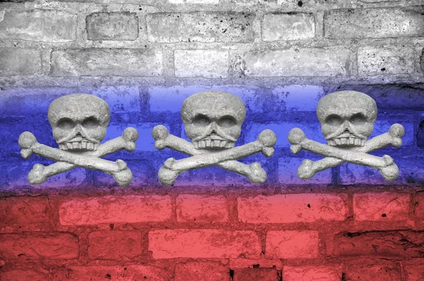 Calaveras y huesos cruzados en un viejo muro de ladrillo pintado con los colores de la bandera de Rusia. Concepto país agresor . — Foto de Stock