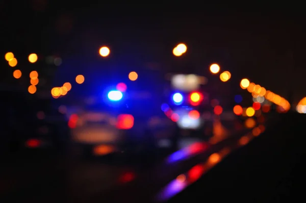 Bir polis arabası, mavi ışık flasher üstüne. Şehir ışıkları arka planda.