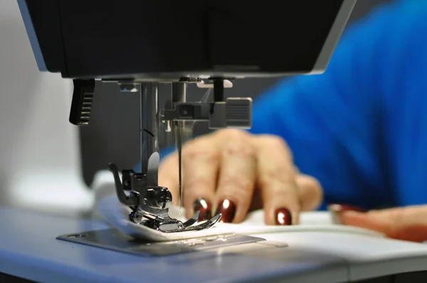 Швейная машинка. На работе девушка с красивым маникюром в руках . — стоковое фото