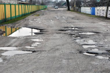 Poor road conditions. Holes in the asphalt, the risk of driving a car, poor asphalt, a dangerous road, potholes in the asphalt.