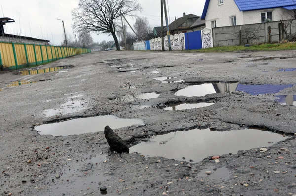 Poor road conditions. Holes in the asphalt, the risk of driving a car, poor asphalt, a dangerous road, potholes in the asphalt.