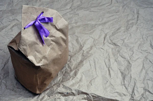 Un paquete de papel kraft marrón con cáñamo como regalo. Envoltura de regalo hecha a mano . — Foto de Stock