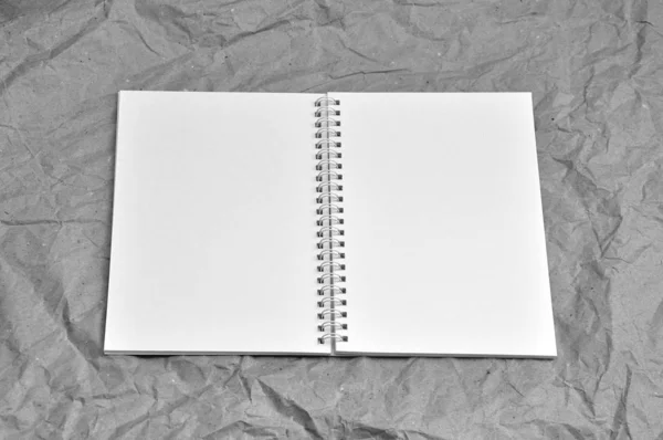 Geopend notitieboekje op een achtergrond van een verfrommeld verpakkingspapier. — Stockfoto