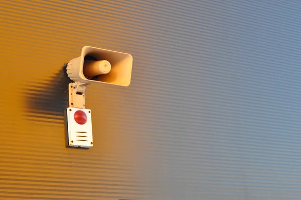 Megaphone for signaling in case of fire on the wall of a warehouse building.
