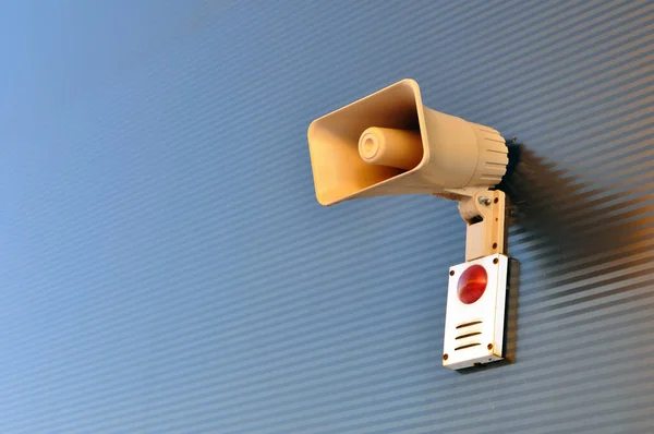 Megaphone for signaling in case of fire on the wall of a warehouse building. — ストック写真