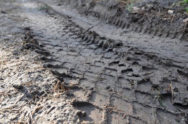 Yerde bir kamyon lastiğinin ayak izleri var, pislik. İz. Yol dışı