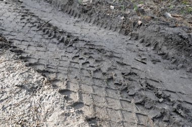 Yerde bir kamyon lastiğinin ayak izleri var, pislik. İz. Yol dışı