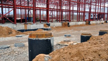 Bir depo kompleksinin inşaatı. Su ve kanalizasyon için beton kuyular. Luke.