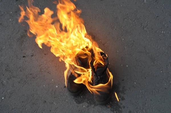 Burning shoes close-up. Burning work shoes shoes. Special shoes on fire.