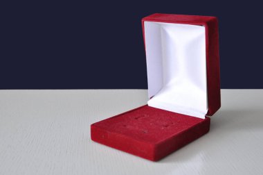 Beyaz bir masada takılar için kırmızı hediye kutusu. Paketleme