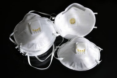 Siyah arka planda beyaz maskeler. Solunum vanalı solunum cihazı, antisprey maske biyolojik etkenlere karşı etkili, covid-19 ya da coronavirus gibi.