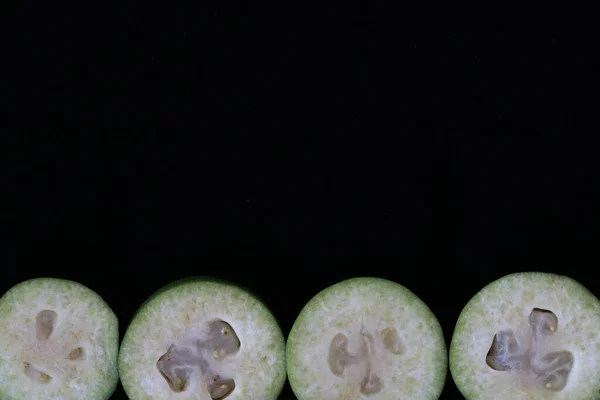 Line Feijoas sliced against black background, Scientific name Acca sellowiana, Healthy and balanced diet eating concept