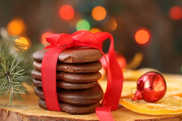 Merry christmas - sweet chokolate cokkie tied with a red ribbon with orange slices, branch of spruce, red glass balls