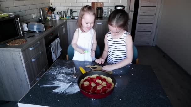 Two little girls sisters make dough for a pie and help mom — Stock Video