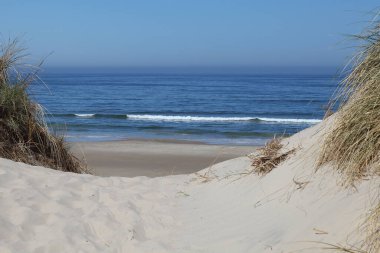 Denize giden bir kumul üzerinde yol