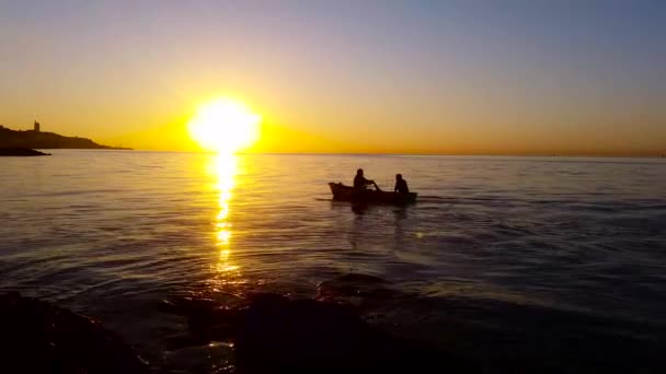La silueta de los hombres con el barco al amanecer - 4K — Vídeo de stock