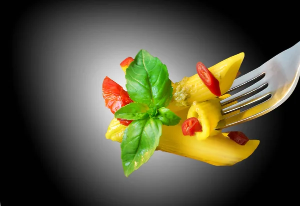 Forkful of penne pasta with basil and hot peppers — Stock Photo, Image