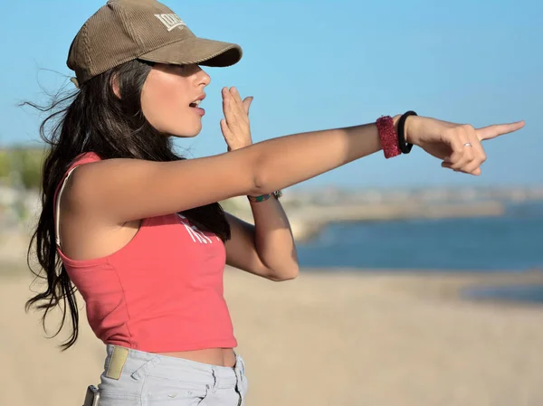 Mädchen zeigt mit dem Arm auf den Strand — Stockfoto