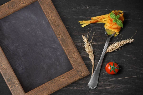 Fork with fettuccine with tomato on an aged black wooden table — Stock Photo, Image