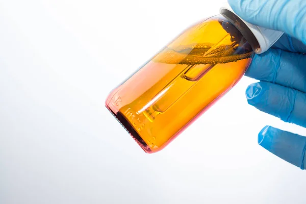 Garrafa com conta-gotas nas mãos do médico no laboratório — Fotografia de Stock