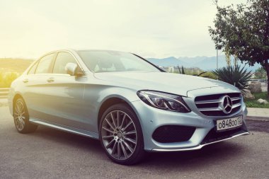 Gümüş Mercedes Benz güneş ışığı altında.