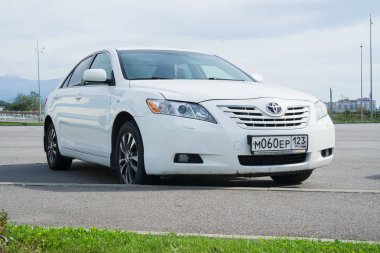 Beyaz Toyota Camry sokakta park edilmiş..