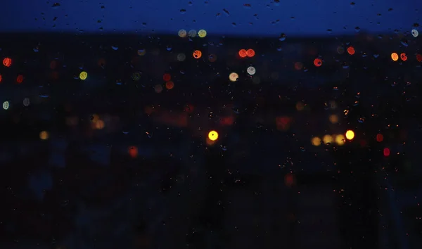 Night city, window and rain drops.