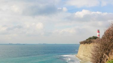 Güzel bir gün, deniz feneri ve deniz sahilinde gemi uzaktan