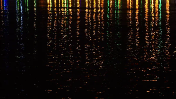 Colored night city lights on water surface. — Stock Photo, Image