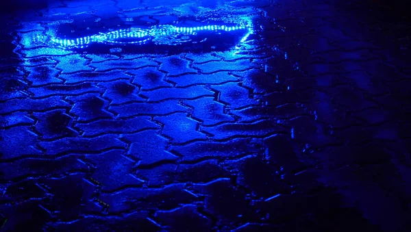 Rain on the night street. Blue light reflection in puddle. — Stock Photo, Image