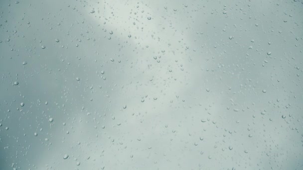 La pluie tombe sur une fenêtre et le ciel vole couvert . — Video