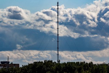 Gökyüzünün arka planında kasvetli bulutlarla dolu bir meteorolojik direğin karanlık silueti. Obninsk, Rusya
