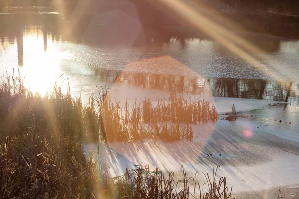 Sun glare and rays at sunset over the river