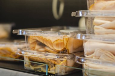 Jambon dilimleri paketlendi ve süpermarket raflarına istiflendi.