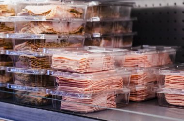Ham slice packed and stacked on supermarket shelves for sale clipart