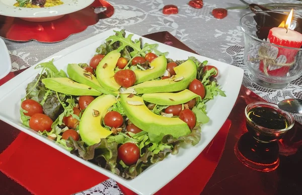 Healthy avocado dish, cherry tomatoes, almond lettuce and for romantic dinner — Stock Photo, Image