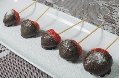 Sevgililer günü kırmızı çilekleri, erimiş acı çikolatayla mavi kapta.