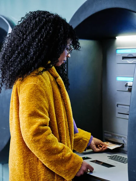 ATM 'den para çeken genç bir kadın.