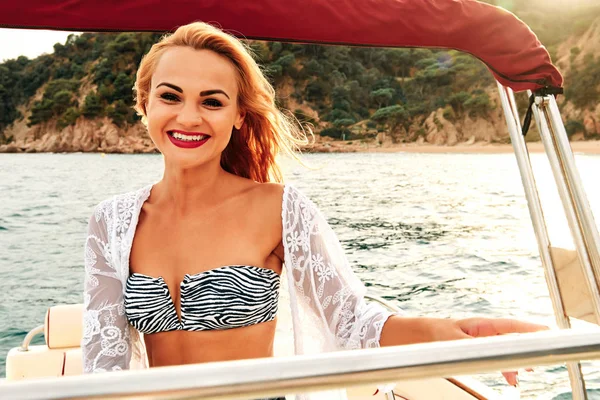 Una giovane donna bionda al tramonto in barca - concetto estivo — Foto Stock
