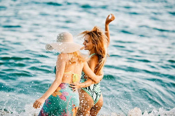 Due giovani donne in spiaggia al tramonto - concetto estivo — Foto Stock