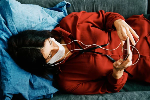 Una Donna Con Telefono Maschera Sul Divano Durante Epidemia Virus — Foto Stock