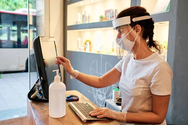Masadaki kadın yüz maskesi kullanıyor - küçük işletme konsepti - koronavirüs salgını