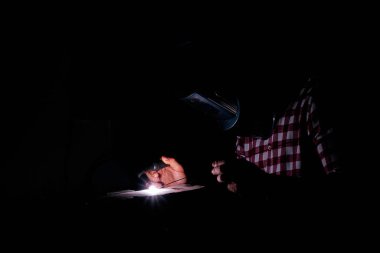 Adam endüstriyel bir atölyede kaynak yapıyor.