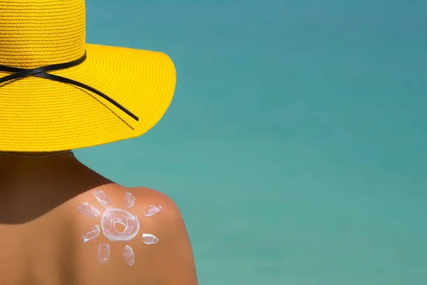 Mujer con crema solar en forma de sol en la playa —  Fotos de Stock