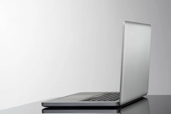 Nový laptop boční pohled s oblíbeným designem na stole. — Stock fotografie
